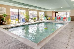 uma piscina no átrio do hotel com cadeiras e mesas em Home2 Suites By Hilton Louisville Airport Expo Center em Louisville