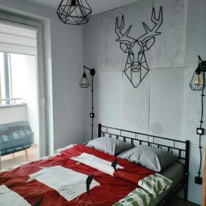 Dormitorio con cama con cabeza de ciervo en la pared en Pszczelna Loft, en Cracovia