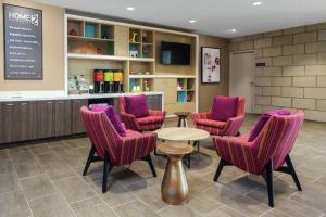 una sala de espera con sillas moradas y una mesa en Home2 Suites By Hilton Louisville Airport Expo Center, en Louisville
