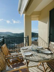einen Tisch und Stühle auf einem Balkon mit Aussicht in der Unterkunft Elena's House in Syvota