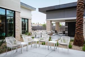 a row of white chairs and tables on a patio at Hilton Garden Inn Las Vegas City Center in Las Vegas