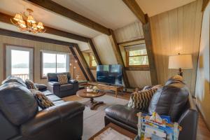 een woonkamer met lederen meubels en een flatscreen-tv bij Cozy Deer Lake Cabin, 3 Mi to Boyne Mtn Resort! in Boyne City