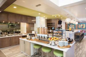 a large kitchen with a counter with green bar stools at Hilton Garden Inn Las Vegas City Center in Las Vegas