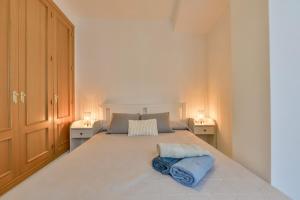 una camera da letto con un grande letto bianco con due lampade di Apartamento San Remo a Calpe Altre 22 foto