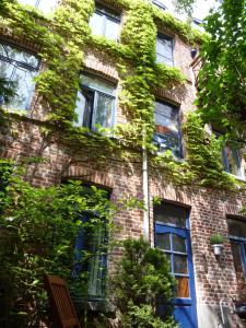 un edificio de ladrillo cubierto de hiedra con ventanas en Chez Christophe, en Lille