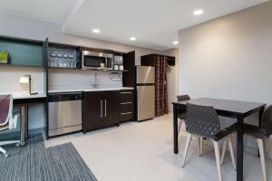 a kitchen with a table and chairs and a microwave at Home2 Suites Smithfield Providence in Smithfield