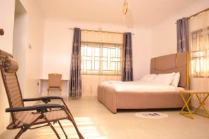 a bedroom with a bed and a chair in it at Casa Nadreya Furnished Home Nakuru in Nakuru +26 photos