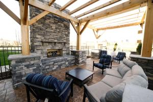 an outdoor patio with a stone fireplace and furniture at Hampton Inn & Suites Forest City in Forest City