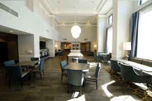 a dining room with tables and chairs and windows at Hampton Inn & Suites Forest City in Forest City