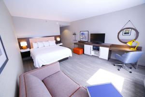 a hotel room with a bed and a desk at Hampton Inn & Suites Forest City in Forest City
