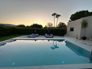 a swimming pool with blue water in a yard at GREEN ESTATE villas in Arménoi