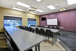 a conference room with tables and chairs and a whiteboard at Tru By Hilton Sumter in Sumter
