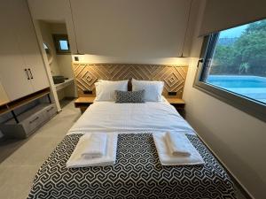 a bedroom with a large bed with two towels on it at GREEN ESTATE villas in Arménoi +71 photos