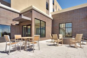 een patio met een tafel en stoelen voor een gebouw bij Hampton Inn & Suites Rexburg in Rexburg