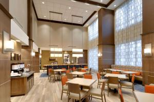a dining room with tables and chairs and windows at Hampton Inn & Suites Rexburg in Rexburg