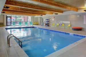 a large swimming pool with blue water in a building at Home2 Suites by Hilton Bloomington in Bloomington