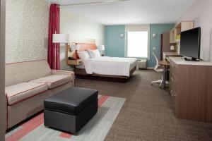 a large hotel room with a bed and a desk at Home2 Suites by Hilton Bloomington in Bloomington