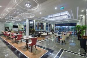 a restaurant with tables and chairs in a building at Hilton Garden Inn Yalova in Yalova