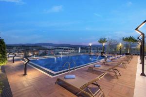 a pool on the roof of a building with lounge chairs at Hilton Garden Inn Yalova in Yalova