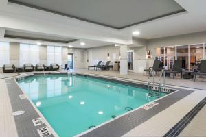 オタワにあるHomewood Suites By Hilton Ottawa Airportのホテルの客室内の青い水の大きなプール