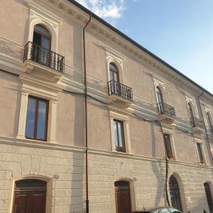 - un grand bâtiment avec des fenêtres et des balcons dans l'établissement La Piazzetta 2 0, à LʼAquila