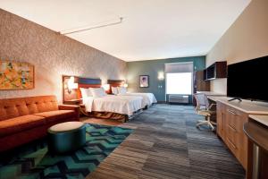a hotel room with a bed and a flat screen tv at Home2 Suites Mechanicsburg in Mechanicsburg