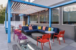 a patio with a blue couch and colorful chairs at Tru By Hilton Little Rock West in Little Rock