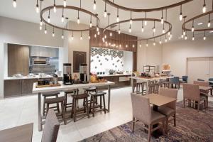 a lobby with tables and chairs and a kitchen at Hilton Garden Inn Omaha Aksarben Village in Omaha