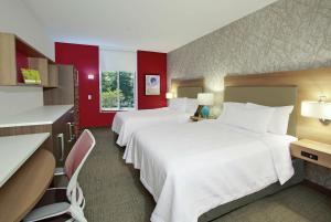 two beds in a hotel room with red walls at Home2 Suites by Hilton Mobile I-65 Government Boulevard in Mobile