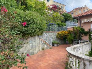a brick walkway leading to a house with flowers at Casa Ribot: Alassio centro e mare a portata di mano in Alassio