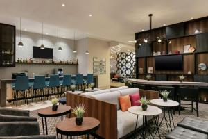 um átrio com um sofá e mesas e um bar em Homewood Suites By Hilton Monterrey Apodaca em Monterrey
