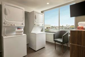 La salle de bains blanche est pourvue d'une chaise et d'une fenêtre. dans l'établissement Homewood Suites By Hilton Monterrey Apodaca, à Monterrey