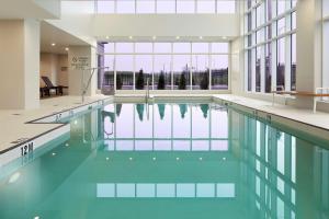 a swimming pool with blue water in a building at Doubletree By Hilton Montreal Airport in Dorval