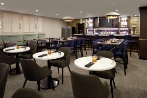 a restaurant with tables and chairs and a bar at Doubletree By Hilton Montreal Airport in Dorval