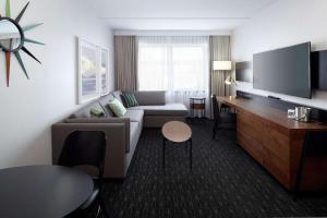 a living room with a couch and a tv at Doubletree By Hilton Montreal Airport in Dorval