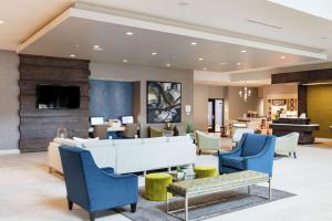 a lobby with blue chairs and a waiting room at Hilton Garden Inn Madison Sun Prairie in Sun Prairie