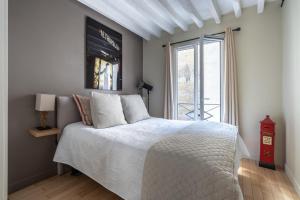 um quarto com uma cama branca e uma janela em Cosy place in Paris em Paris