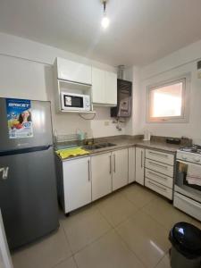 a kitchen with white cabinets and a stainless steel refrigerator at Departamento Centro in Santiago del Estero