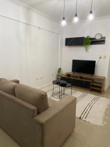 sala de estar con sofá y TV de pantalla plana en Departamento Centro en Santiago del Estero