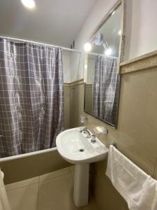 a bathroom with a sink and a shower with a mirror at Departamento Centro in Santiago del Estero