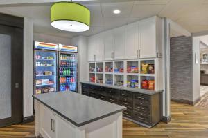 a kitchen with a large refrigerator with drinks in it at Homewood Suites By Hilton Savannah Airport in Savannah
