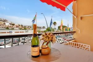 a bottle of wine and a flower on a table on a balcony at Nice studio Bart 50 meters from Playa Las Vistas in Arona