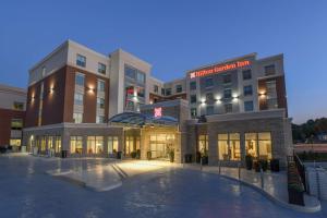 a large building with a pool in front of it at Hilton Garden Inn Cincinnati Midtown in Cincinnati