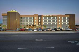Home2 Suites by Hilton Victorville في فيكتورفيل: مبنى كبير به سيارات تقف في موقف للسيارات