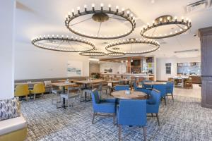 a dining room with tables and blue chairs at Hilton Garden Inn Cincinnati Midtown in Cincinnati
