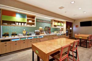 a large kitchen with a table and a dining room at Home2 Suites by Hilton Victorville in Victorville
