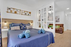 a bedroom with a blue bed with blue pillows at Nice studio Bart 50 meters from Playa Las Vistas in Arona