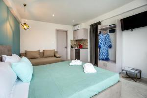 - une chambre avec un grand lit vert et 2 serviettes dans l'établissement Otium Studios, à Limenaria