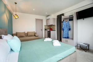 a bedroom with a large green bed with two towels at Otium Studios in Limenaria