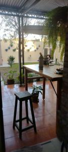 a wooden table with a stool on a patio at SOLES Hostel Boutique in Rosario